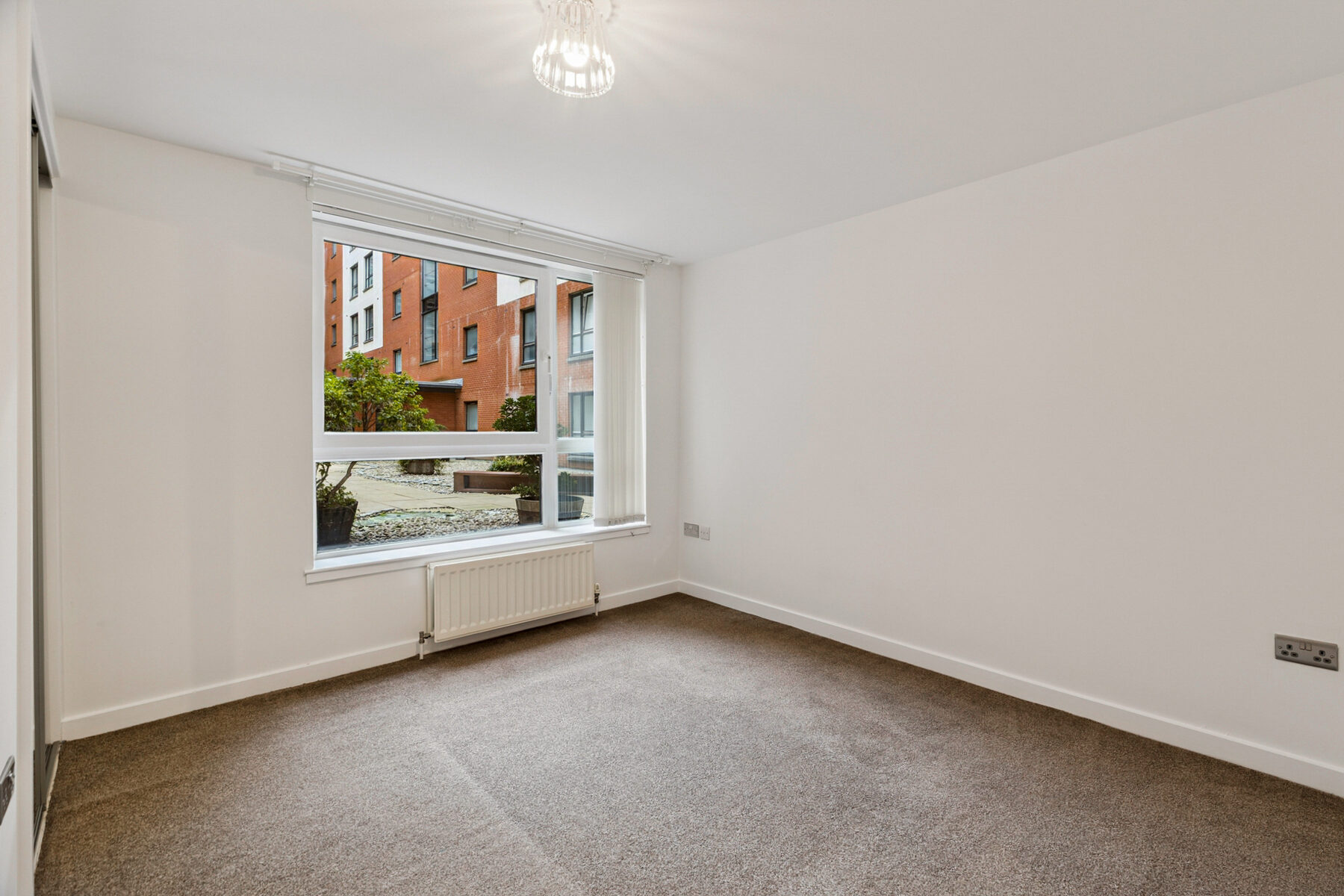 Bedroom with picture window overlooking the residents' landscaped courtyard